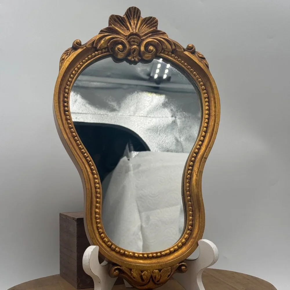 French-style ornate wall mirror, rococo or baroque decorative elements in a gil